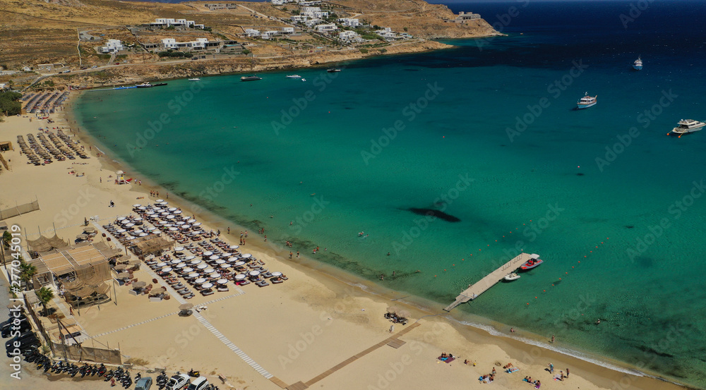 Aerial drone photo of famous organised with sun beds and umbrellas beach of Kalo Livadi with emerald clear sandy sea shore, Mykonos island, Cyclades, Greece  