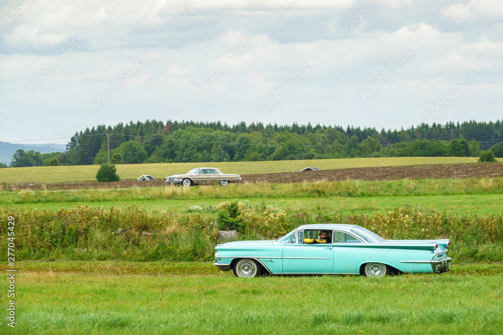 Classic cars driving in the countryside Classic cars driving in the countryside
