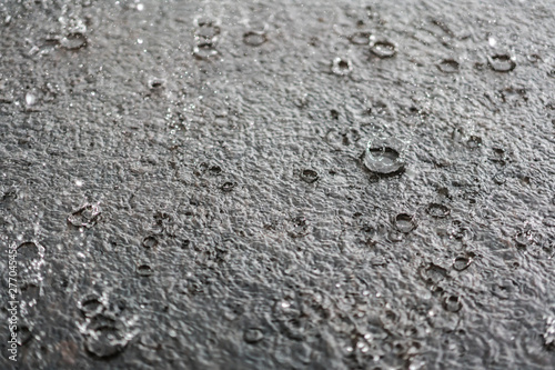 rain gray background. Drops on a puddle