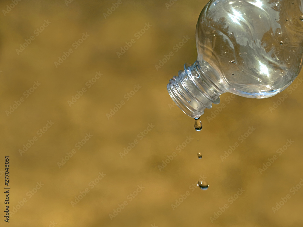 last drop of water from empty plastic bottle on dried up grass background, close up, concept of water scarcity, drought last drop of water from empty plastic bottle on dried up grass background, close up, concept of water scarcity, drought