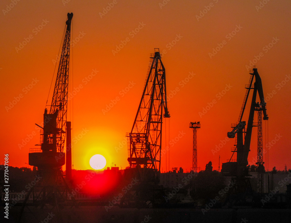 Construction cranes at sunset in the port of Odessa, Black Sea, Ukraine
