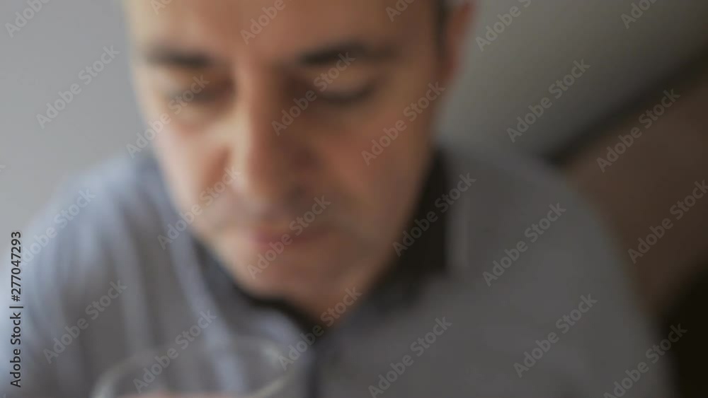 Closeup of a man ingesting a pill and drinking it with a glass of water Closeup of a man ingesting a pill and drinking it with a glass of water