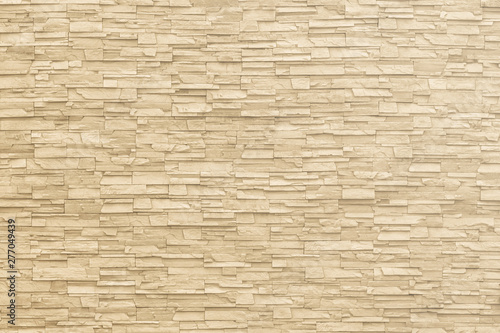 Rock stone brick tile wall aged texture detailed pattern background in yellow cream beige color