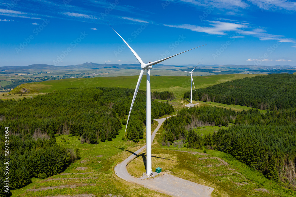 © whitcomberd - Aerial drone view of turbines at a large onshore windfarm on a green hillside (Pen y Cymoedd, Wales)