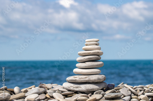 A stack of colored pebbles on the background the sky and sea