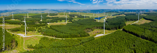 Aerial drone panorama of turbines at a large onshore windfarm in Wales, UK