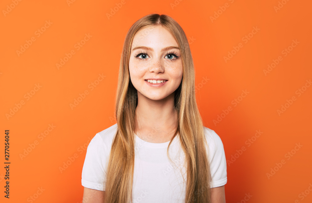 Smiling happy beautiful little blonde girl in white t-shirt isolated on colorful background and looks on camera Smiling happy beautiful little blonde girl in white t-shirt isolated on colorful background and looks on camera