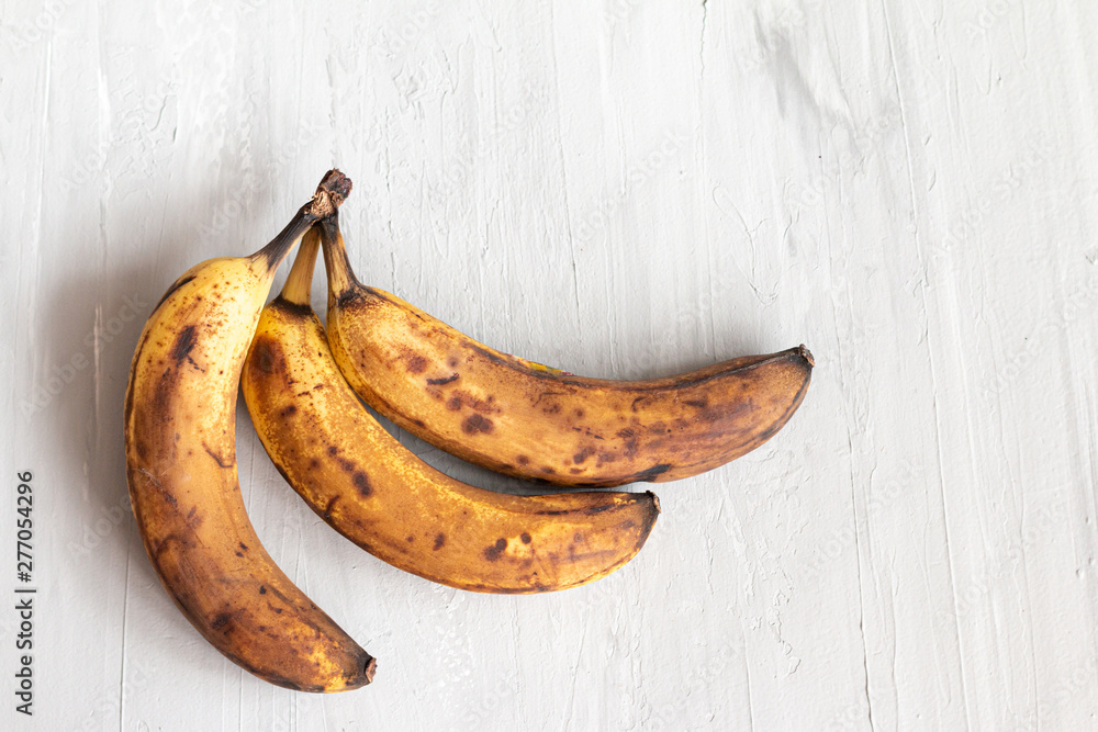 spoiled tainted bananas on grey background. Ugly food trendy photo. Food waste, food garbage spoiled tainted bananas on grey background. Ugly food trendy photo. Food waste, food garbage