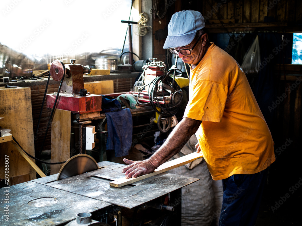 Carpenter cutting wood in workshop Carpenter cutting wood in workshop