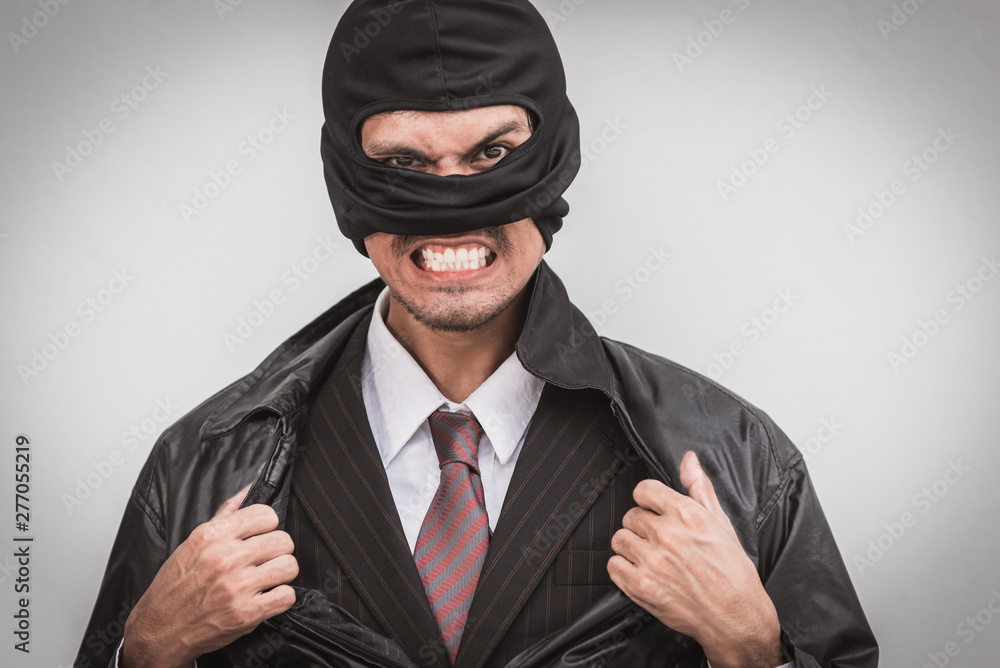Robber in classic businessman pose tearing open shirt Robber in classic businessman pose tearing open shirt