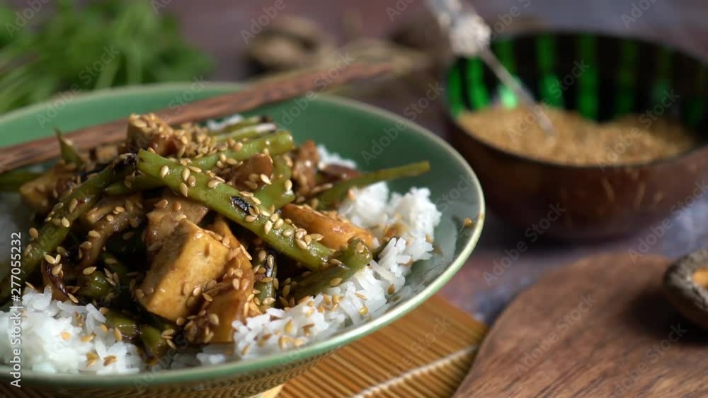 Extreme closeup dolly to the left of Szechuan green beans and tofu with sesame seeds. Extreme closeup dolly to the left of Szechuan green beans and tofu with sesame seeds.