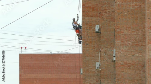 Two climbers hang on the building. Industrial alpinism. 