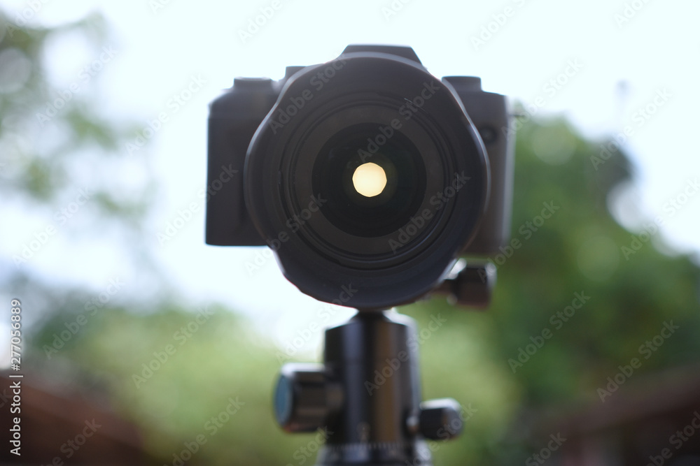 black camera on tripod with light pass pass through aperture