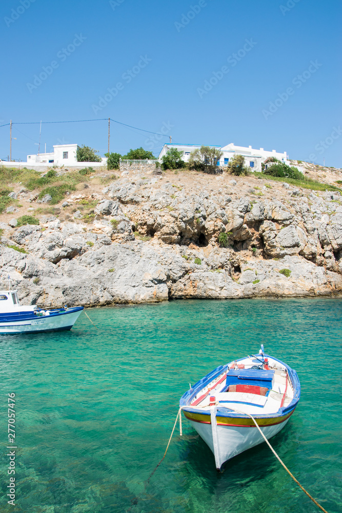 Fototapeta premium Little port with colorful fishing boats and turquoise sea waters in Potamos village in Antikythera island in Greece
