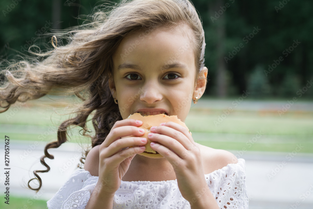 Cute little girl eating fast food hamburger Cute little girl eating fast food hamburger