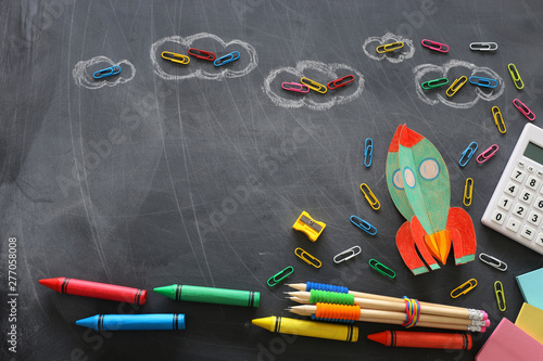 education. Back to school concept. rocket cut from paper and painted over blackboard background. top view, flat lay