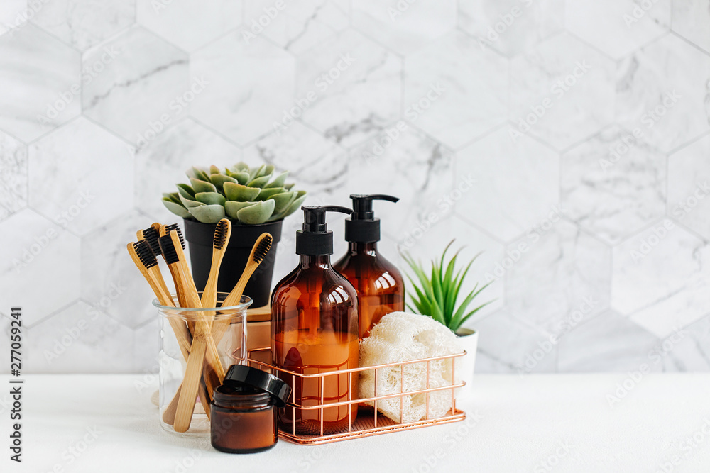 Bathroom accessories, natural cosmetics products and tools with green plant on white table inside a bathroom background. - obrazy, fototapety, plakaty 