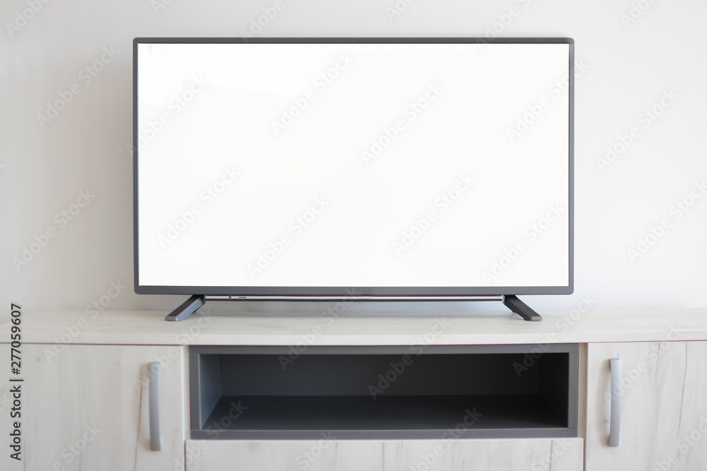 Smart Tv on light gray cabinet with white blank screen. Mockup TV concept. Smart Tv on light gray cabinet with white blank screen. Mockup TV concept.