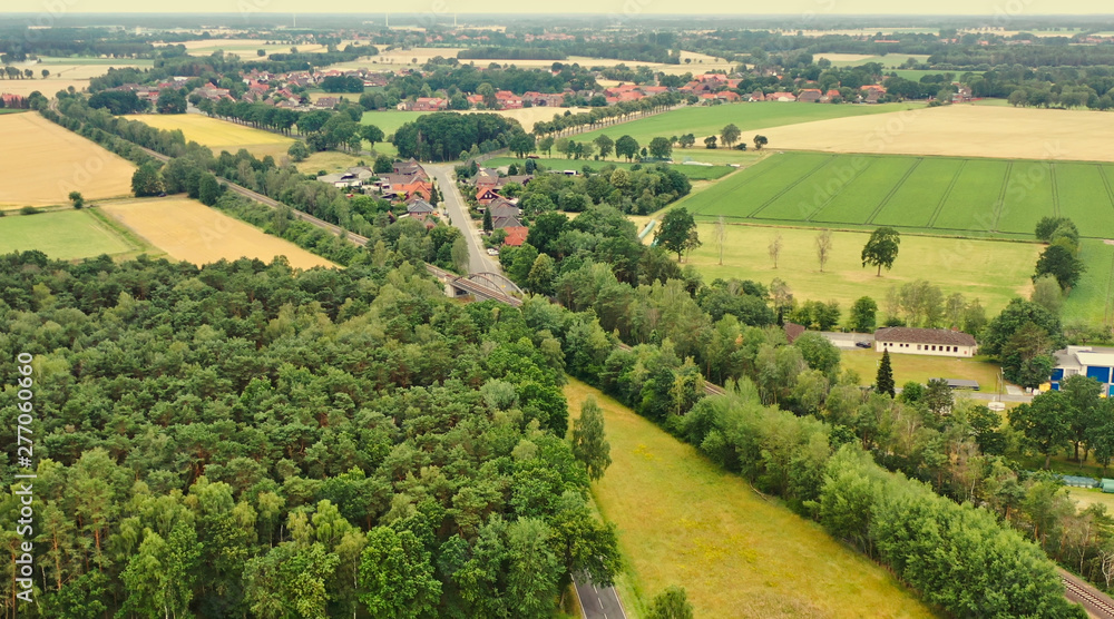 Aerial view of a small German village in the flat region of northern Germany with pastures, arable land and cows.