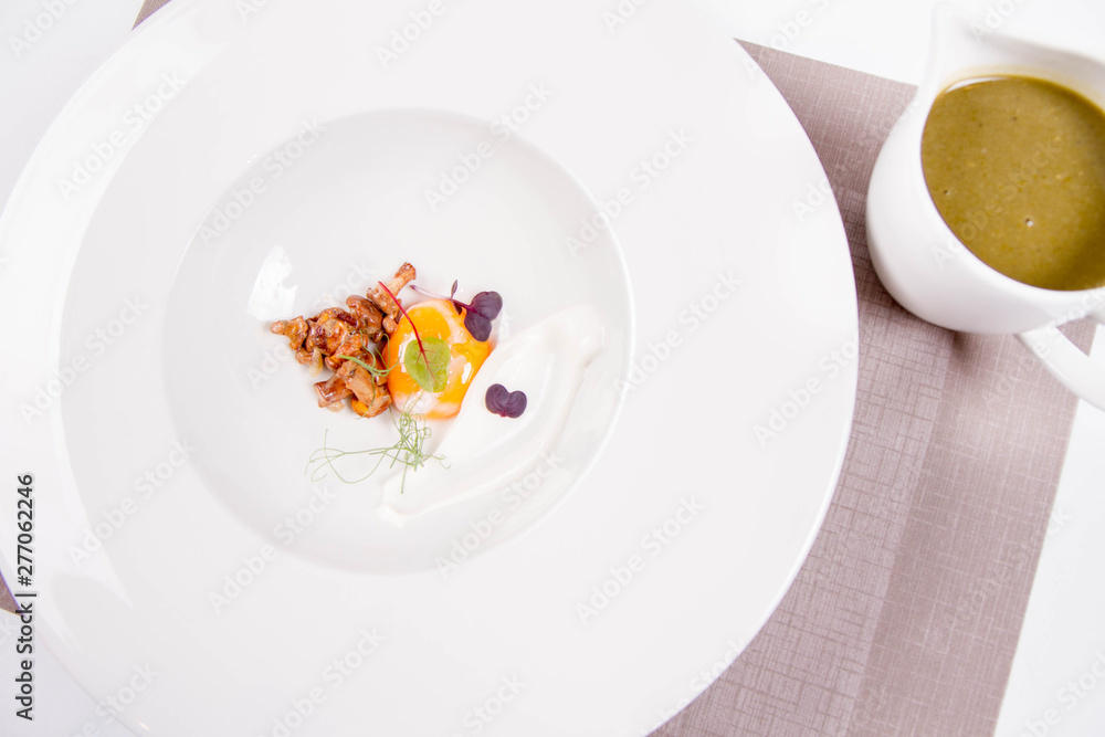 Young sorrel cream with a sous-vide egg yolk, chanterelles and fresh cream, soup served in a jug Young sorrel cream with a sous-vide egg yolk, chanterelles and fresh cream, soup served in a jug