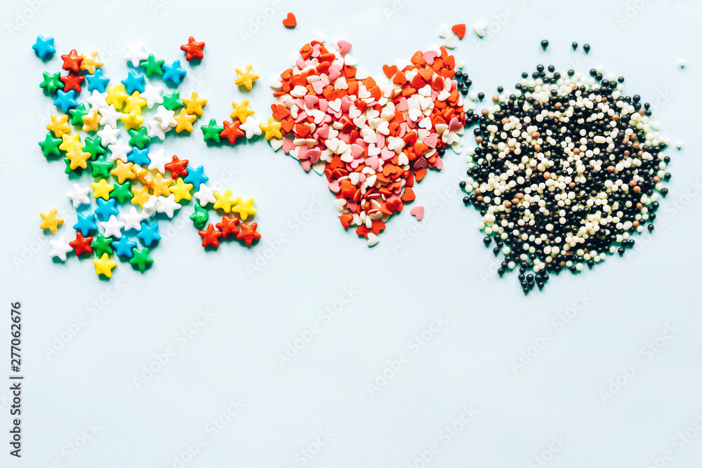 Three heaps of multi-colored dragee lollipops on a background top view. Summer sweet flat lay. Three heaps of multi-colored dragee lollipops on a background top view. Summer sweet flat lay.