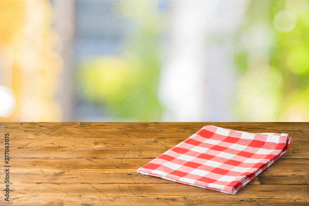 Obraz premium Empty wooden table with tablecloth over abstract bokeh background