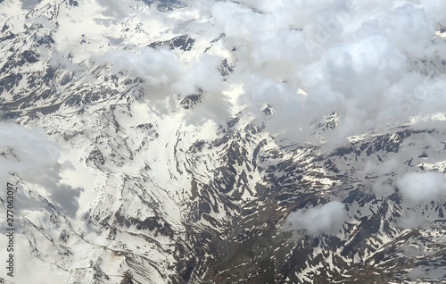 Aerial view of the cloudy Alps between Swiss and Italy seen on a flight