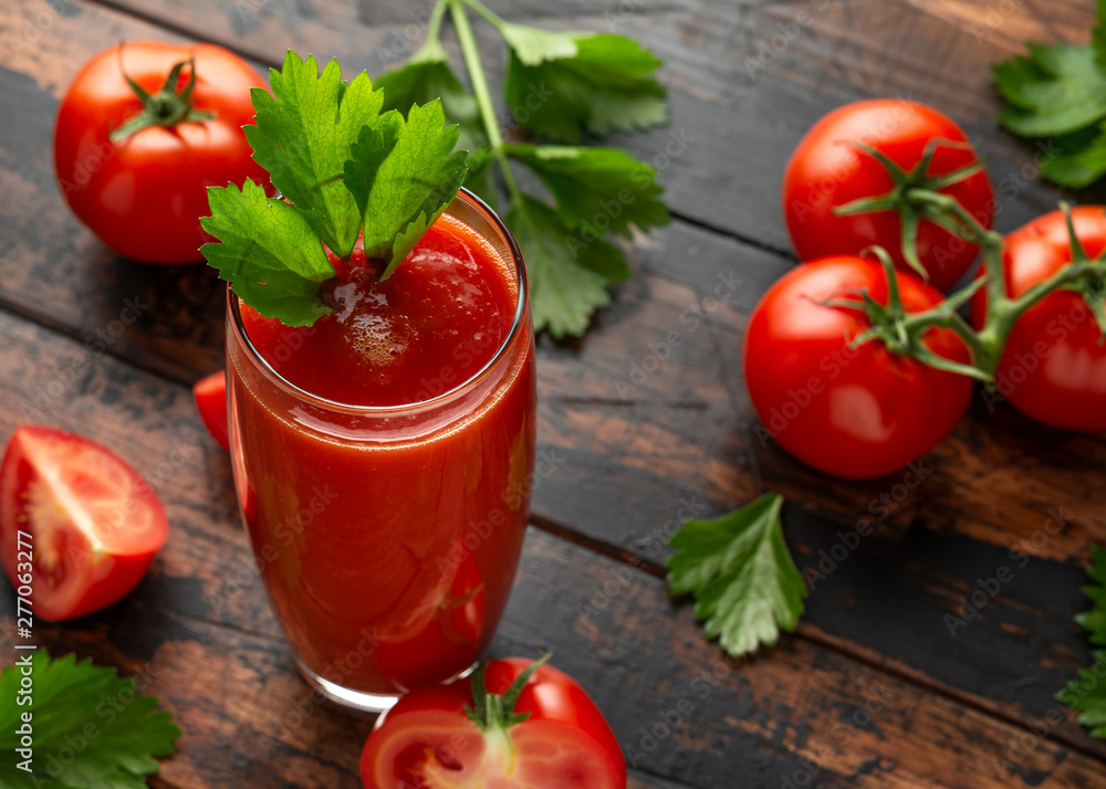 Tomato juice in glass with celery on rustic wooden table Tomato juice in glass with celery on rustic wooden table