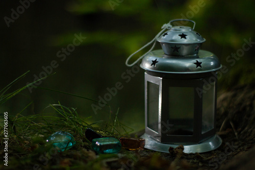 Silver lamp with three glass color stones in a forest