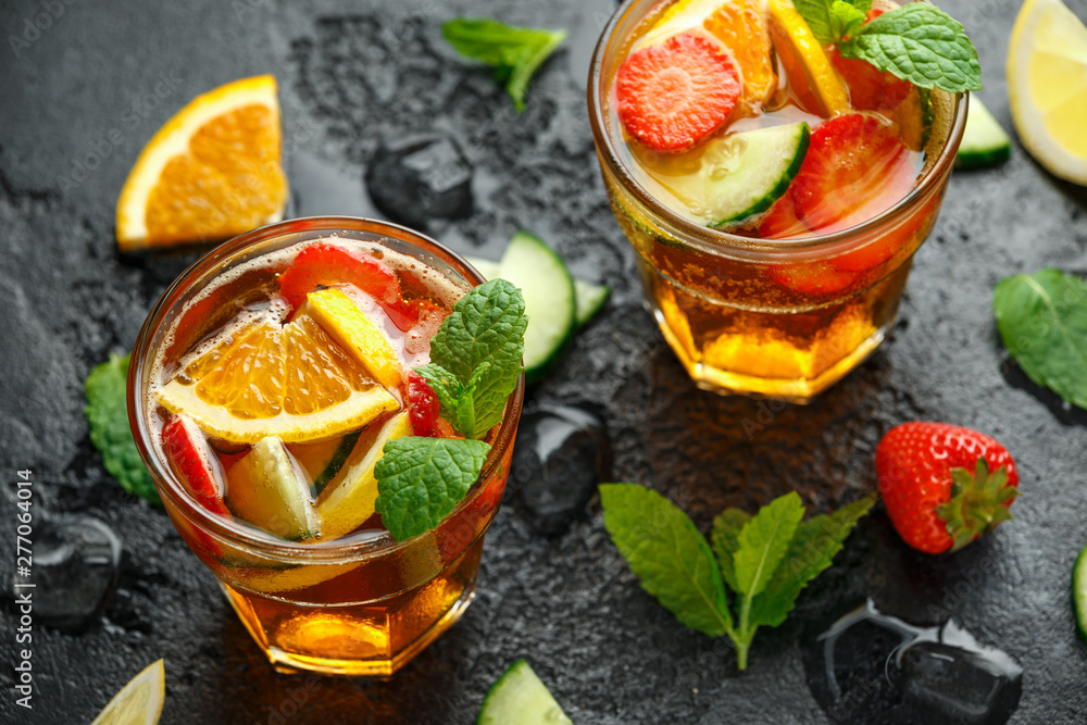 Refreshing Pimms Cocktail with Fruit and vegetables on rustic black table Refreshing Pimms Cocktail with Fruit and vegetables on rustic black table
