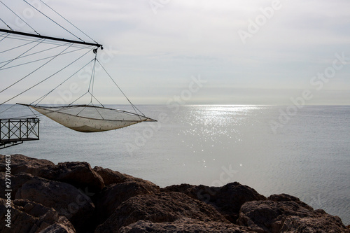 Shore-operated lift net at the Port of Senigallia, Province of Ancona, Marche, Italy, glittering Adriatic Sea water surface in te background, Chinese fishing net