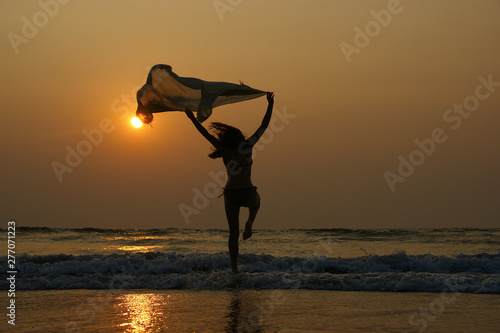 Dancer silhouette. Beautiful girl dancing alone on the beach