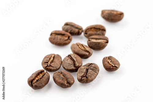 Coffee grains isolated on white background. Top view at an angle. For design.