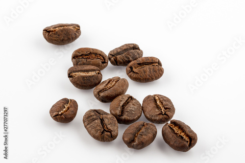 Coffee grains isolated on white background. Top view at an angle. For design.