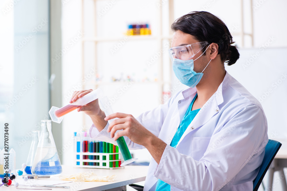 Young male chemist working in the lab Young male chemist working in the lab