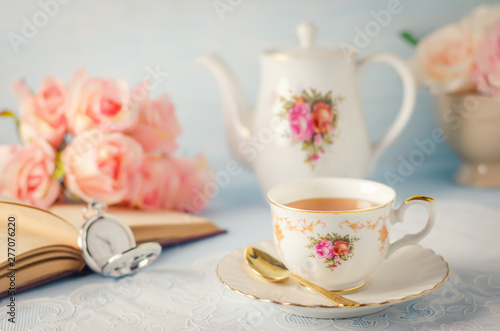 Cup of tea with teapot and flowers with vintage tone