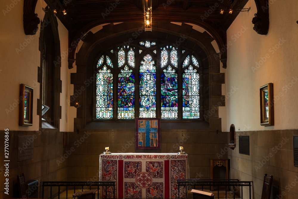 Indoor photo of a small church with lead glass windows and altar