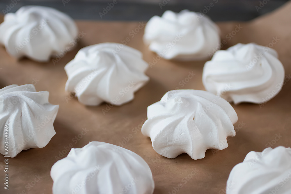 White meringues on brown paper. Preparation for dessert Pavlova.