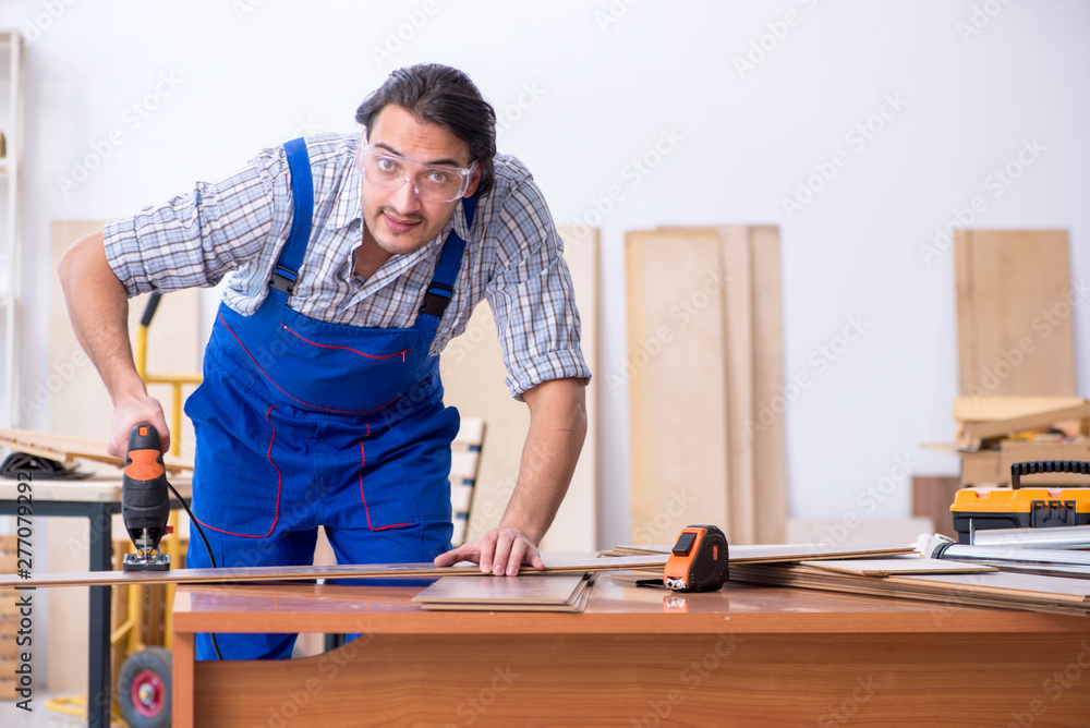 Young male carpenter working indoors Young male carpenter working indoors