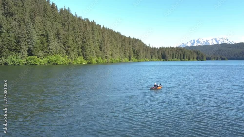 Aerial shot of a woman kayaking on beautiful mountain lake. Bear Lake, Seward, Alaska. Aerial shot of a woman kayaking on beautiful mountain lake. Bear Lake, Seward, Alaska.