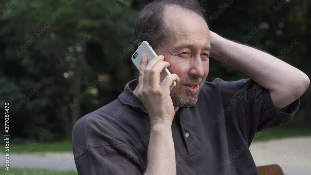 Portrait shot of a senior man talking on a cellphone, scratching his head doubtfully looking Portrait shot of a senior man talking on a cellphone, scratching his head doubtfully looking