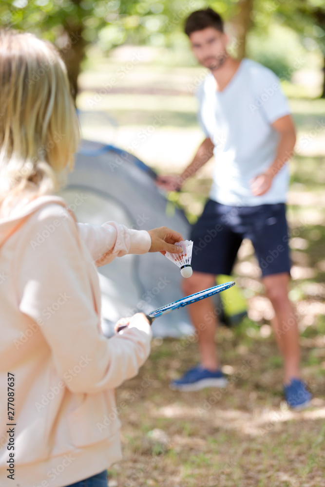 Fototapeta premium young couple playing badminton while on camping holiday