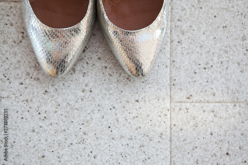 Close-up of the brides silver shoes toes on the marble floor