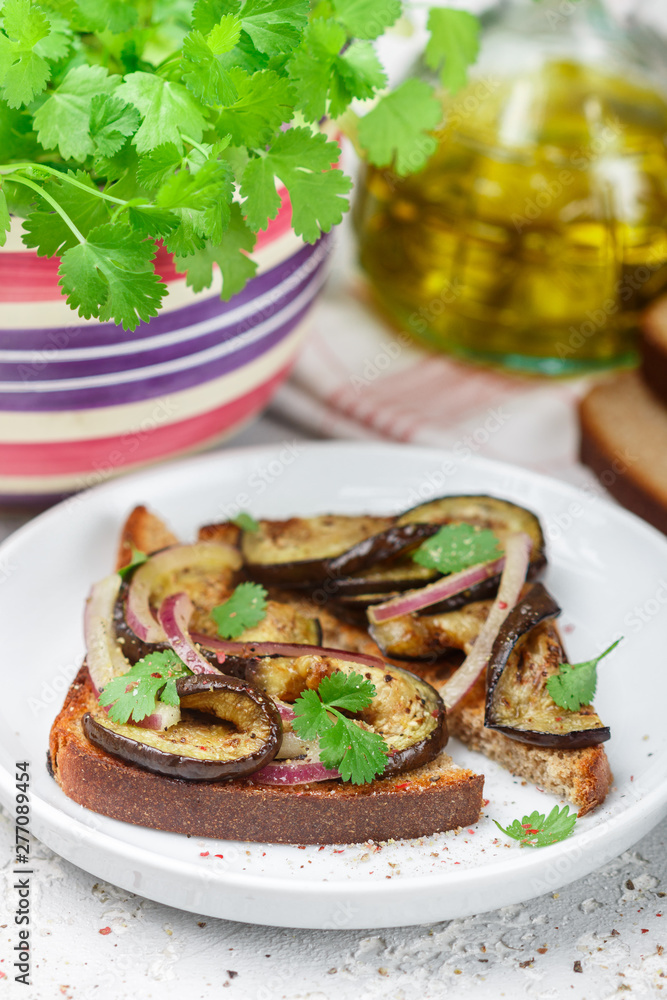 Gourmet rye bread sandwich with fried or baked eggplant, red onion, cilantro and spices. Mediterranean appetizer. Selective focus Gourmet rye bread sandwich with fried or baked eggplant, red onion, cilantro and spices. Mediterranean appetizer. Selective focus