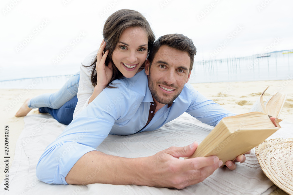 happy lovers reading a book together - obrazy, fototapety, plakaty 