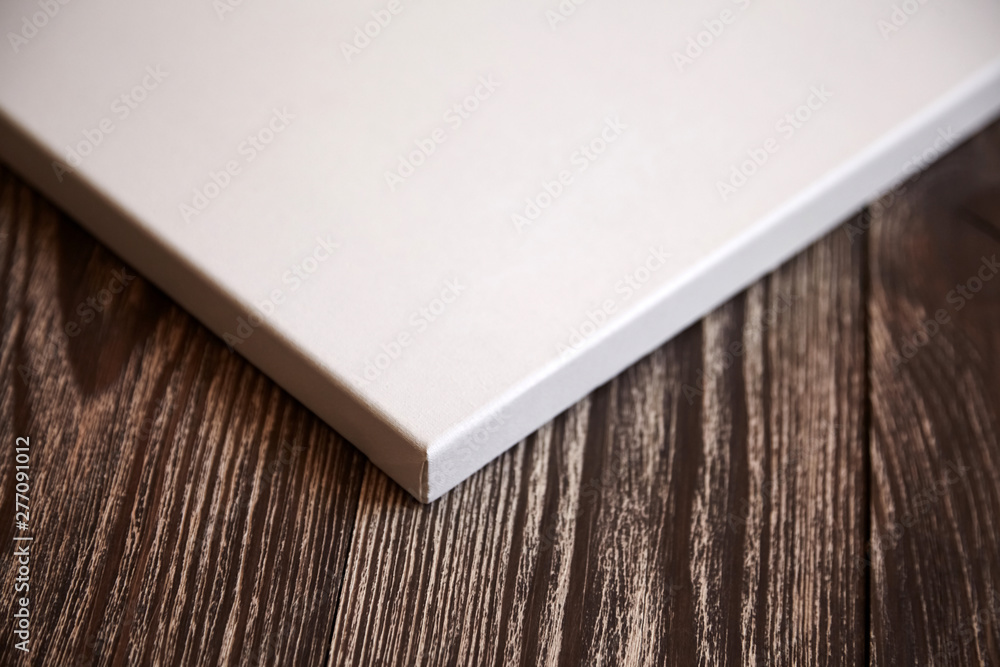 Fototapeta premium Artistic white blank cotton canvas on brown wooden background. Mockup