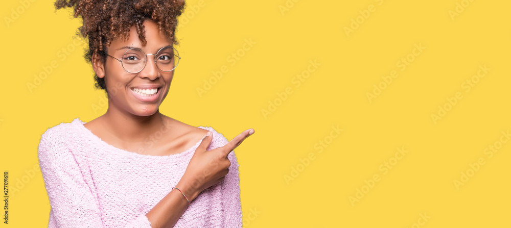 Beautiful young african american woman wearing glasses over isolated background cheerful with a smile of face pointing with hand and finger up to the side with happy and natural expression on face Beautiful young african american woman wearing glasses over isolated background cheerful with a smile of face pointing with hand and finger up to the side with happy and natural expression on face