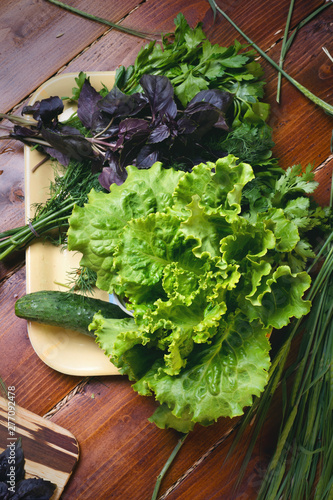 cooking green  salad from organic vegetables around wooden table. flat lay photo