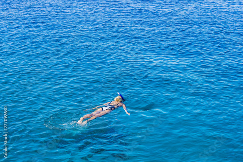 aerial photography from drone of swimming and snorkeling girl enjoy by clean and beautiful Red sea water nature environment, summer vacation background concept picture with empty copy space for text