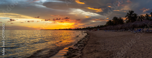 Canvas Print Beautiful Panoramic view of a sandy beach, Playa Ancon, on the Caribbean Sea in Triniday, Cuba, during a dramatic cloudy sunset